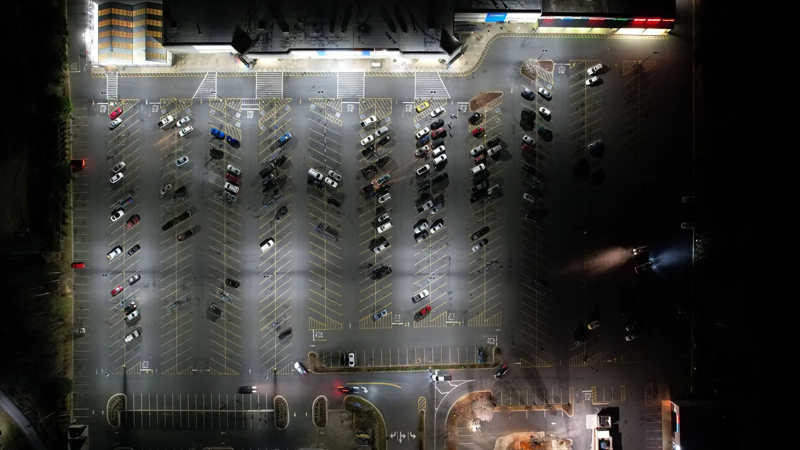 Vista aérea de estacionamento à noite, ilustrando o CEP de pernoite do veículo